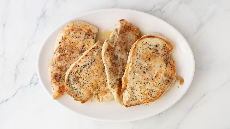Four seared cutlets on a large platter