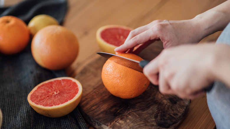 Someone cutting grapefruit