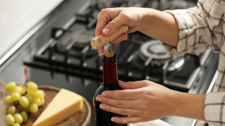 person opening a bottle of wine