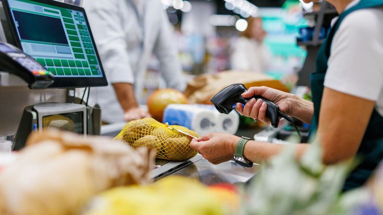 An employee scanning potatoes at a grocery store.
