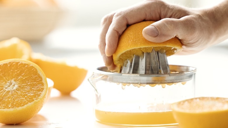 hand juicing a fresh orange