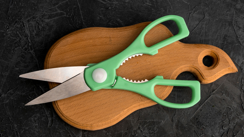Colorful kitchen shears on wooden board