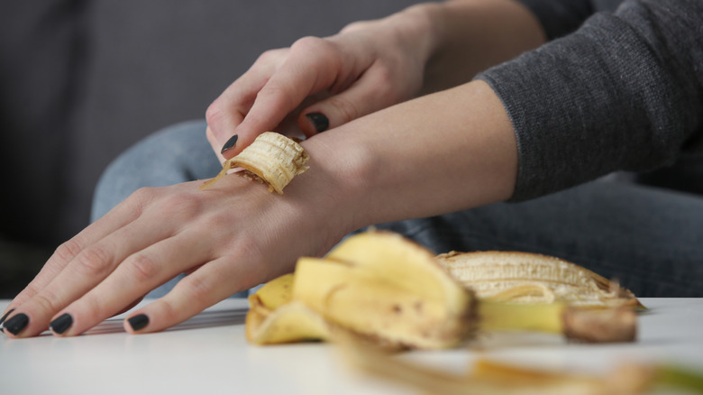 A woman rubbing banana peels on her skin