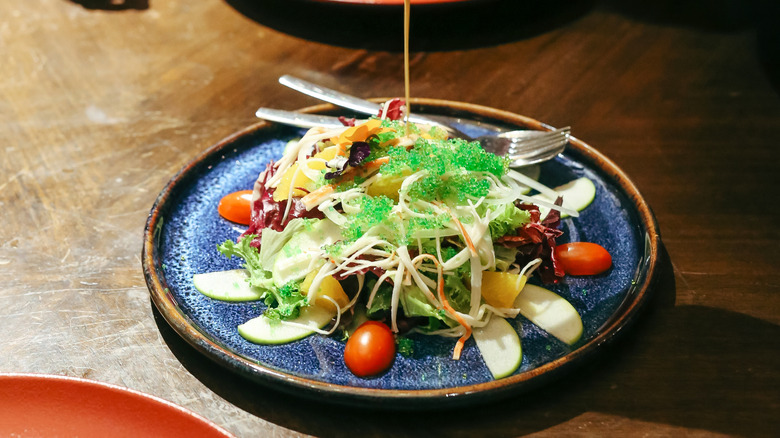 lemon dressing poured onto greens