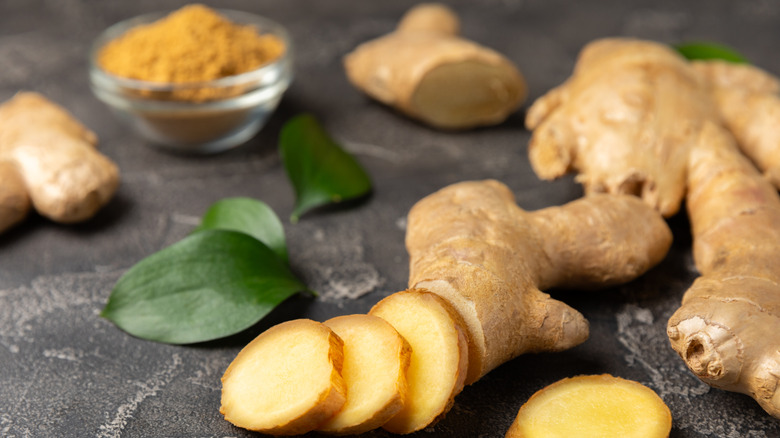 Fresh ginger sliced on a wooden board.