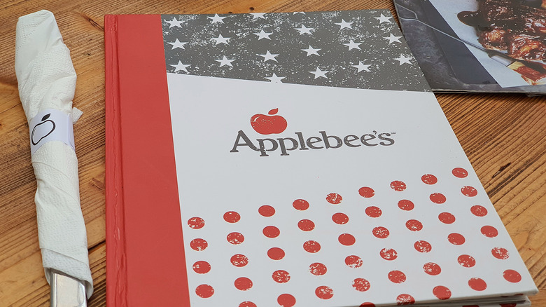 Applebee's menu and silverware on a table
