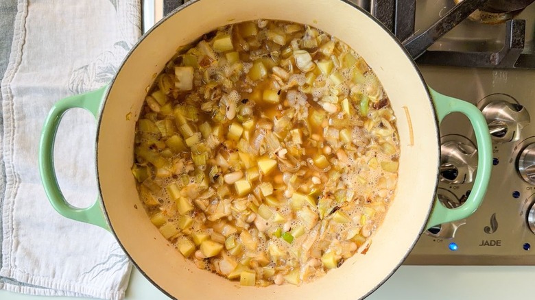 Cabbage soup ingredients boiling in Dutch oven on stovetop