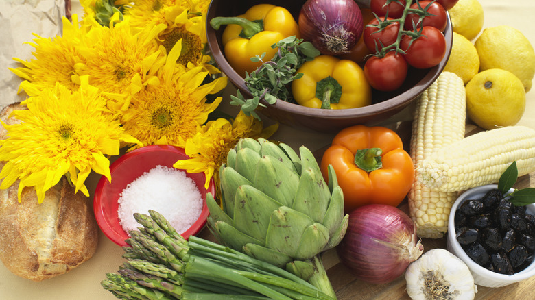 Vegetables and sunflowers on table