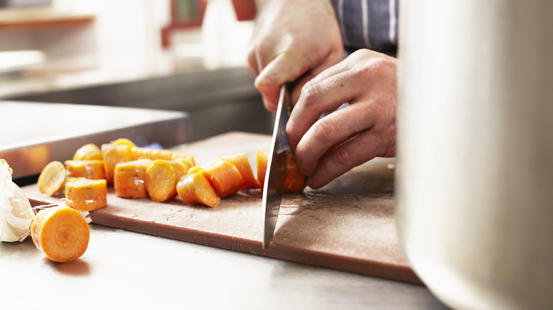 Chopping carrots on cutting board