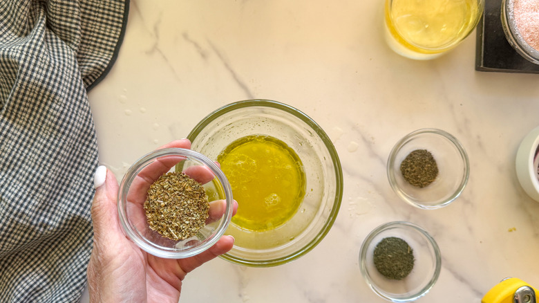hand adding spices to bowl