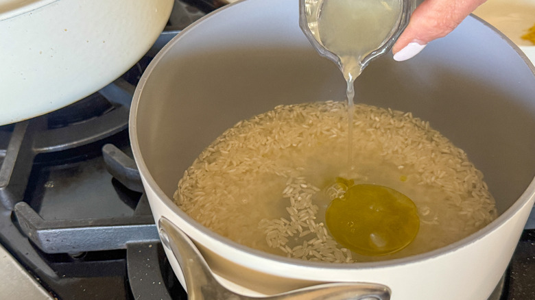 hand adding lemon juice to pot
