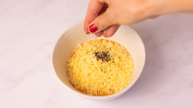pepper sprinkling into bowl 
