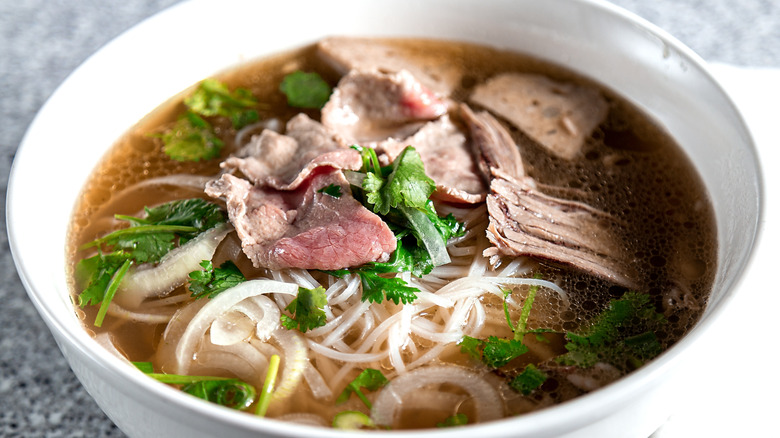 A closeup of a bowl of Vietnamese pho soup with meat