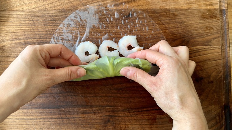 hands rolling stuffed summer roll