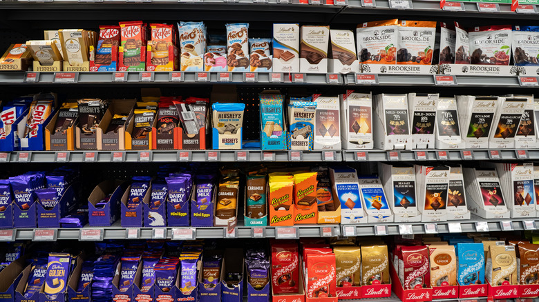 Assorted chocolate bars on grocery store shelves.