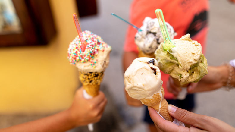 Multiple people holding their ice cream cones together