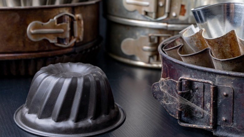 Vintage cast iron baking molds sitting on a kitchen counter.
