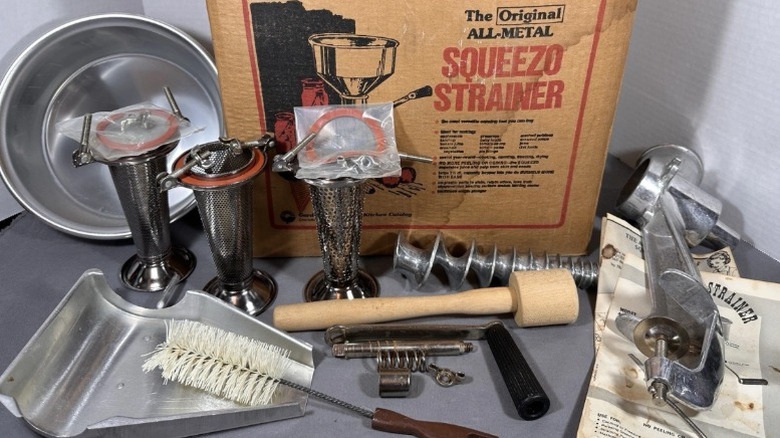 The original metal Squeezo Strainer with all of its attachments and manuals sitting right outside of its box.