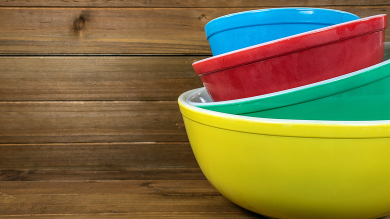 Vintage colorful Pyrex mixing bowls in various colors nested on top of each other.