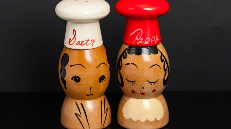 A unique wood set of salt and pepper shakers in the shape of a man and woman.