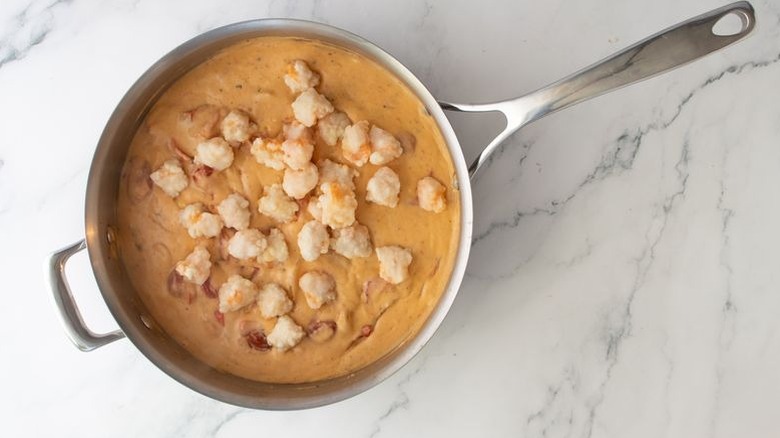Lobster bisque and lobster meat in skillet