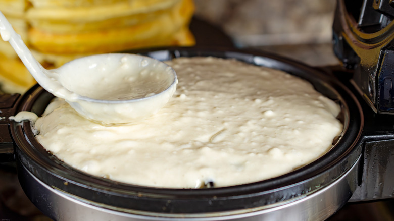 Raw batter poured into waffle iron press