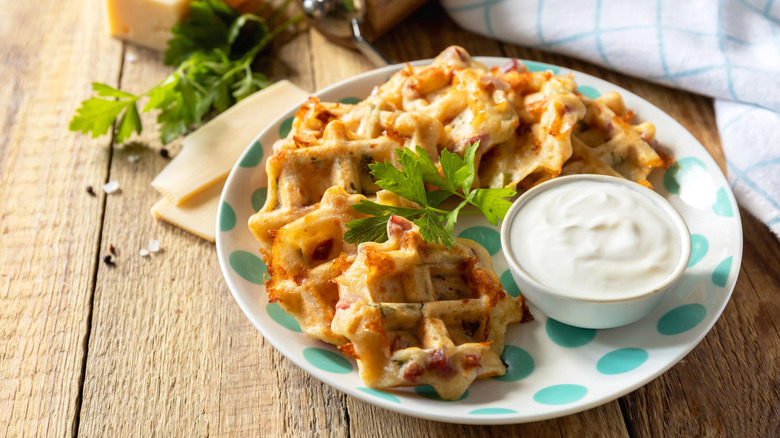 Savory mini waffles on a plate with sour cream