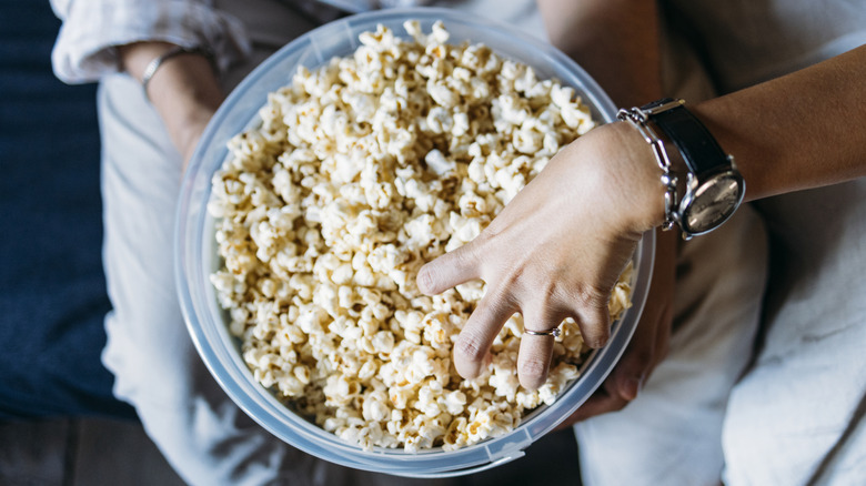 Hand reaching into a shared bowl of popcorn