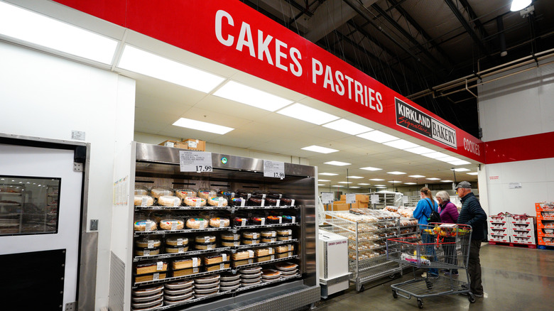 People are seen at a Costco bakery counter.