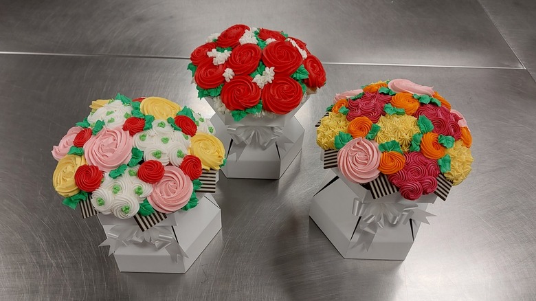 Three Walmart cupcake bouquets on metal counter