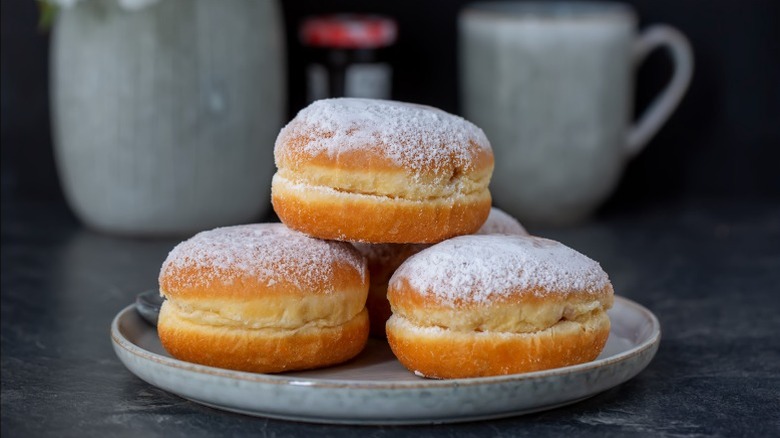 Plate of Berliner jelly donuts with powdered sugar.