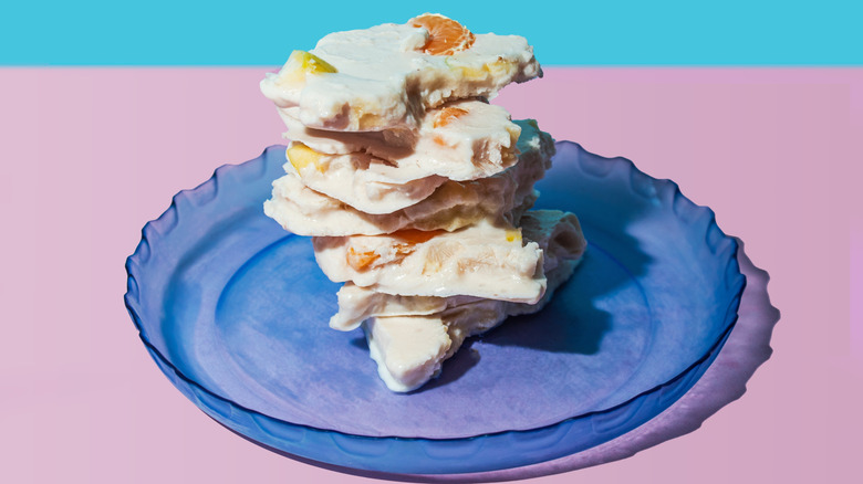 Stack of frozen cottage cheese bark chunks on a blue plate.