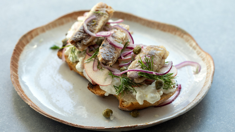 Crostini with cottage cheese, apples, onions, capers, and sardines.