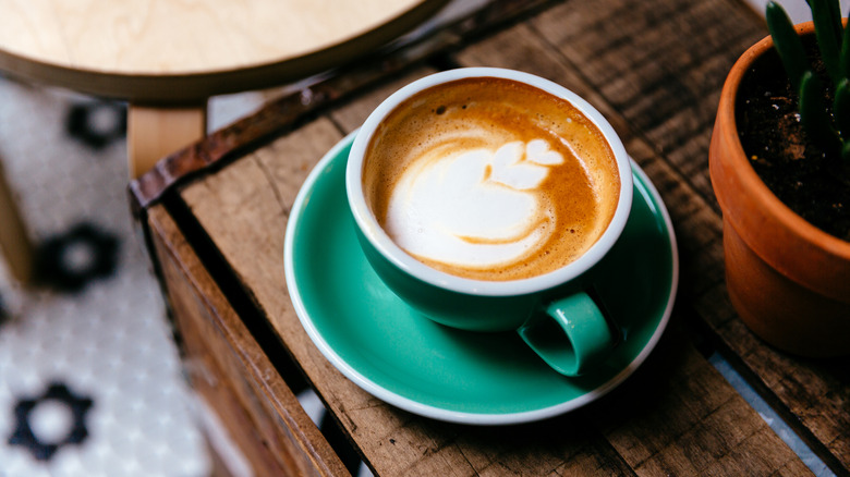 mocha latte in a green mug on wooden chest