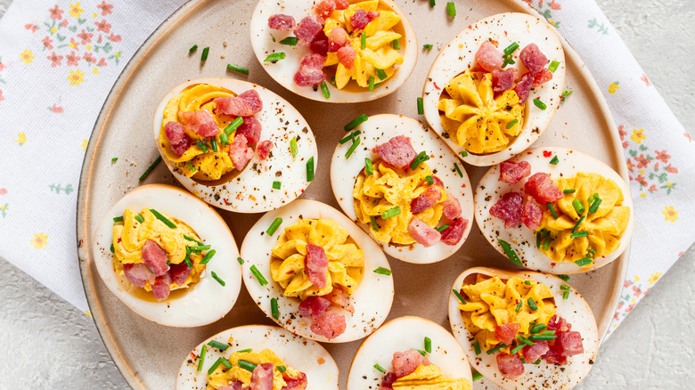 Stuffed deviled eggs on a plate with seasonings