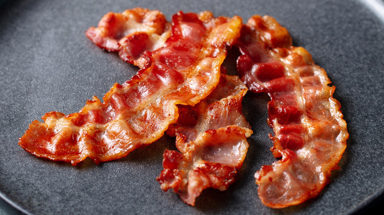 strips of bacon on a gray plate