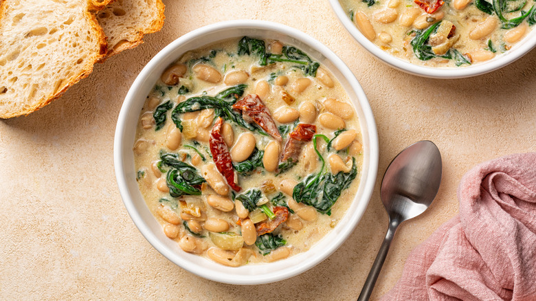 Bowls of Italian butter bean stew with sun-dried tomatoes and spinach.