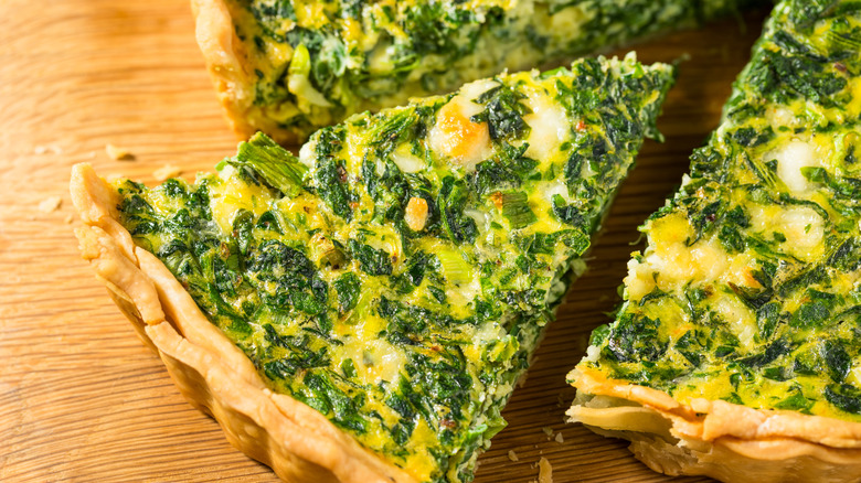 Overhead view of sliced spinach quiche.