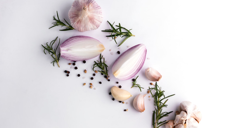 Garlic, herbs, and shallots on a white background