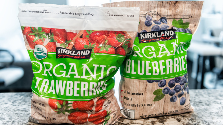 Bags of Kirkland Signature organic frozen strawberries and blueberries on a kitchen counter