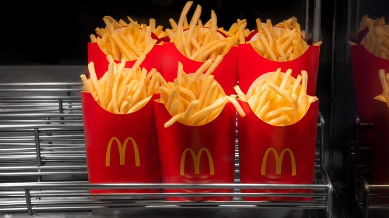 Six containers of McDonald's fries on a metal rack