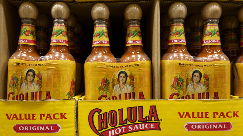 several bottles of Cholula hot sauce on display in a store