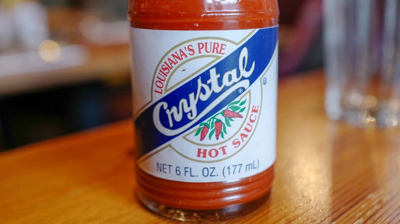 a close up photo of a bottle of Crystal Hot Sauce on a table