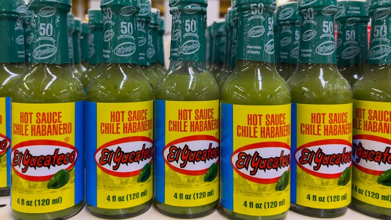 several bottles of El Yucateco Green Habanero on a store shelf