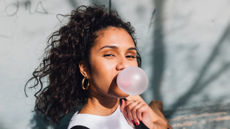 Person blowing a bubble with a piece of gum
