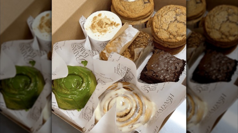 Cinnamon rolls, cookies, and other BadAsh Bakes baked goods in a box