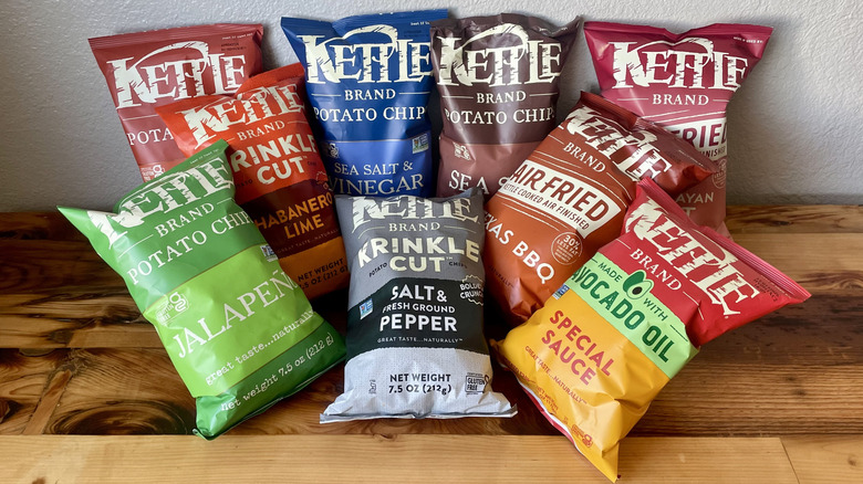 Various flavors of Kettle Brand Potato Chip bags on a wooden table