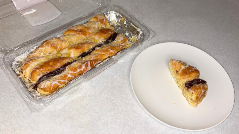 Strawberry cheese danish in a tray and one slice on a tray.