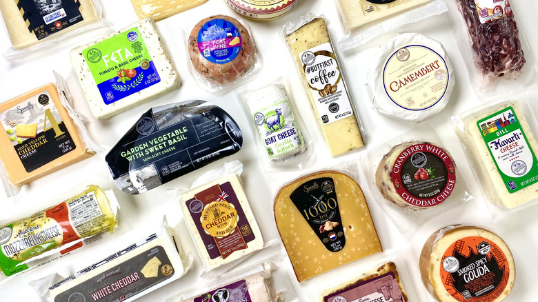 Assorted Aldi cheeses in the packaging on a white surface