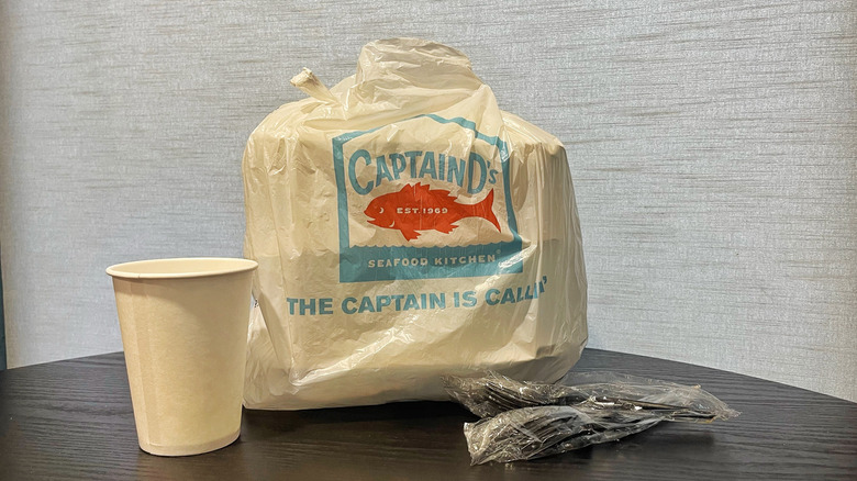 A Captain D's takeout bag filled with boxes on table